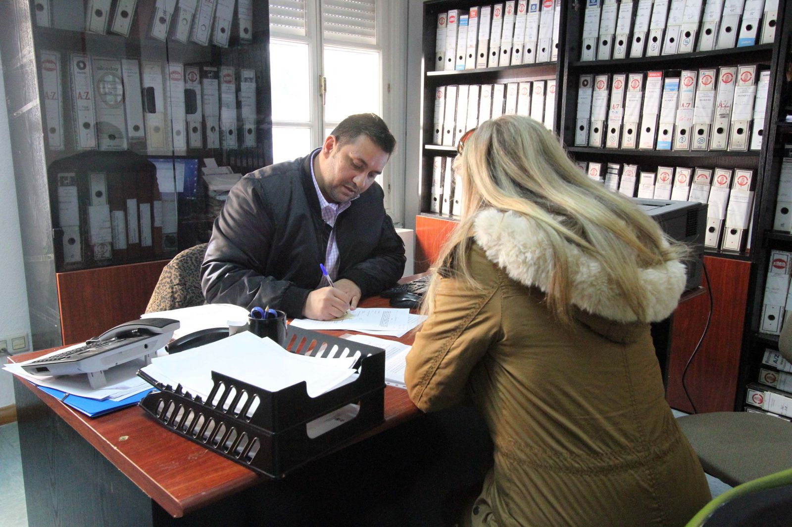 El técnico Bartolomé Heredia atiende a una vecina en la Oficina de Información de Ayudas por Catástrofes Naturales, el pasado jueves en La Línea.