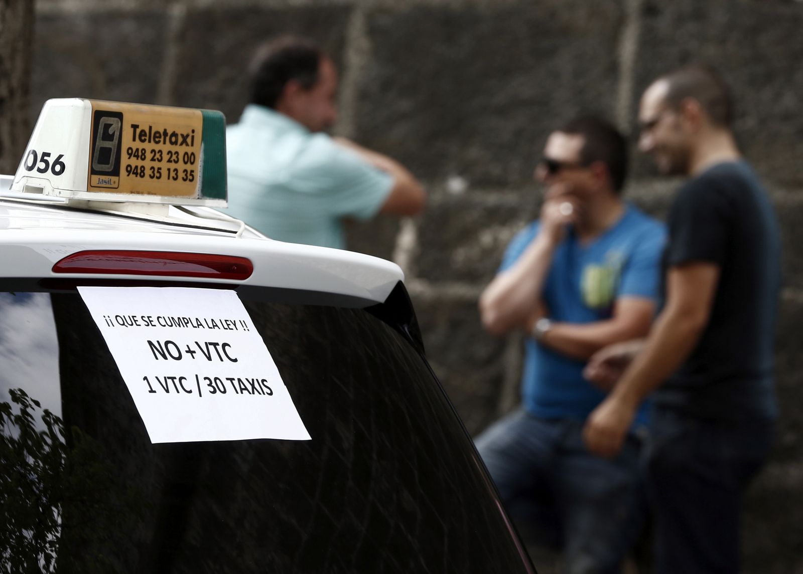 Un taxi de Pamplona con carteles contra la actividad de los vehículos de alquiler con conductor.