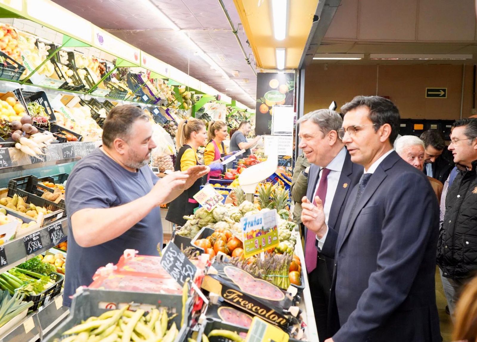 El ministro Luis Planas y el alcalde de Granada hablan con un dependiente en el mercado municipal Merca80