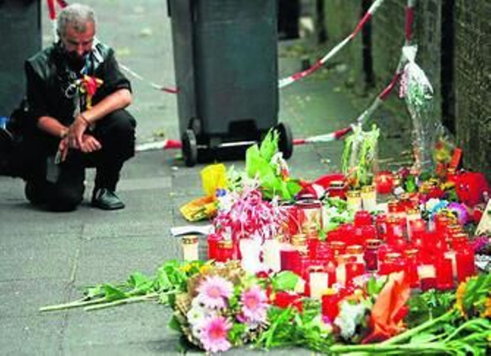 1. Varios hombres sacan a una mujer herida durante la estampida 2. Basura desperdigada prolifera en la zona donde se produjo la tragedia horas después de la catástrofe. 3. Decenas de velas y flores recuerdan a las 19 víctimas de la avalancha en la 'Love Parade'. 4. Dos mujeres lloran por una de las víctimas 5. Una vista aérea de la multitud que se congregó en la localidad de Duisburgo para asistir al festival de música 'tecno'.