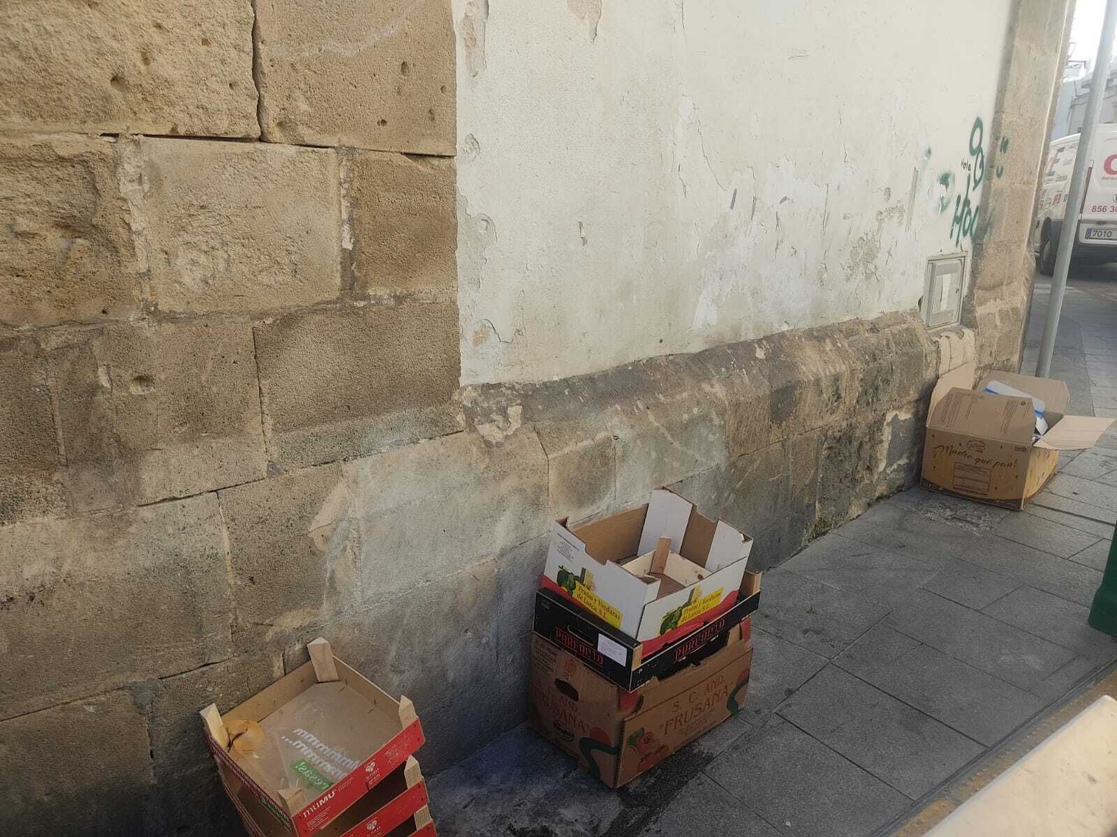 Cajas de cartón junto a la fachada del mercado de abastos.