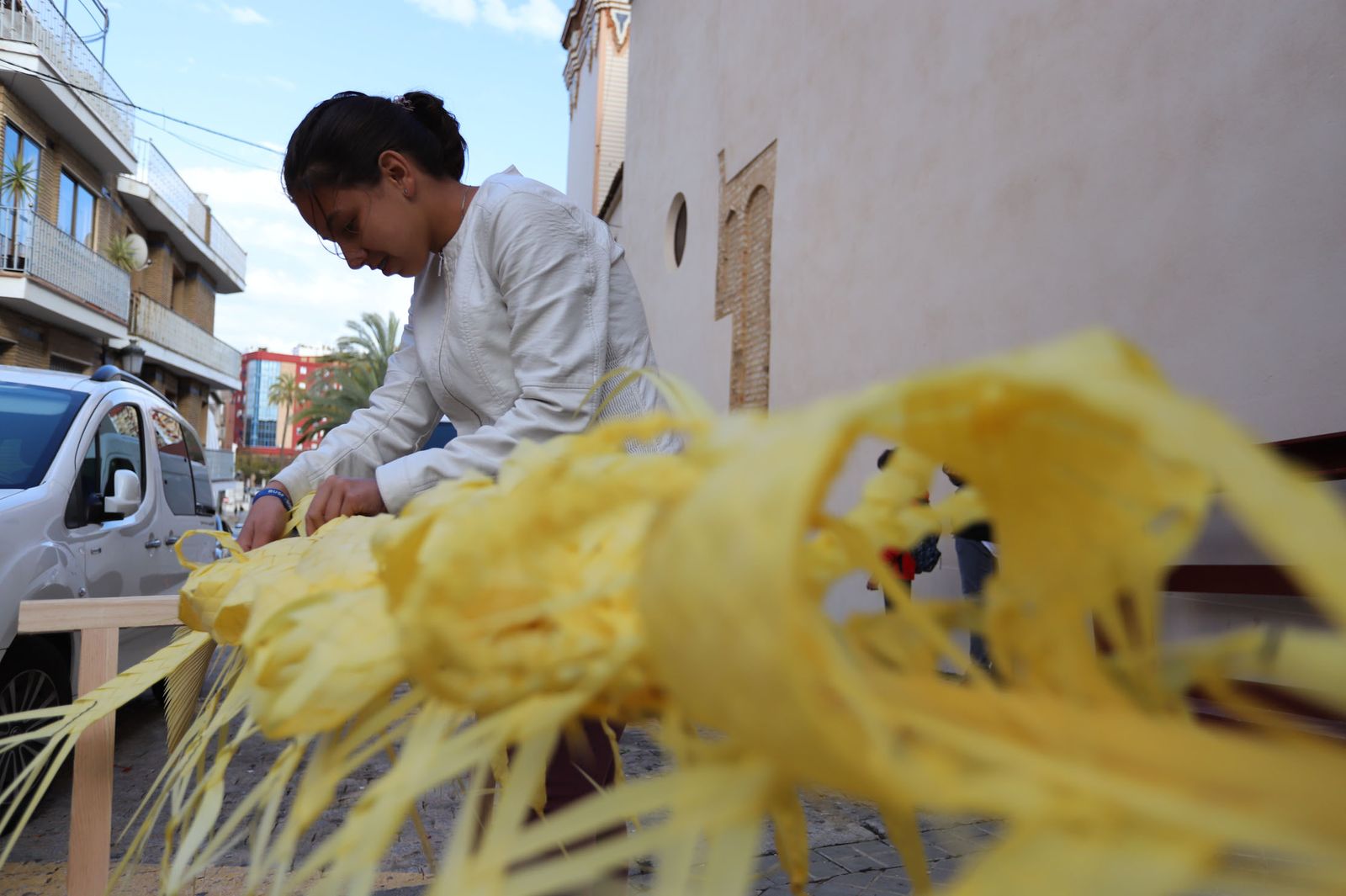 Las puertas de la iglesia de San Pedro acogen estos días las labores de rizado de palmas.