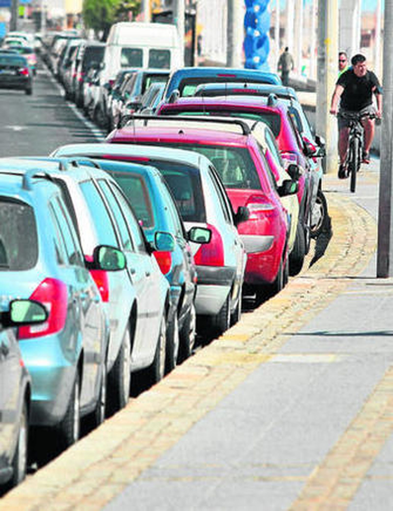 Una hilera de coches aparcados junto a la acera del Paseo Marítimo.