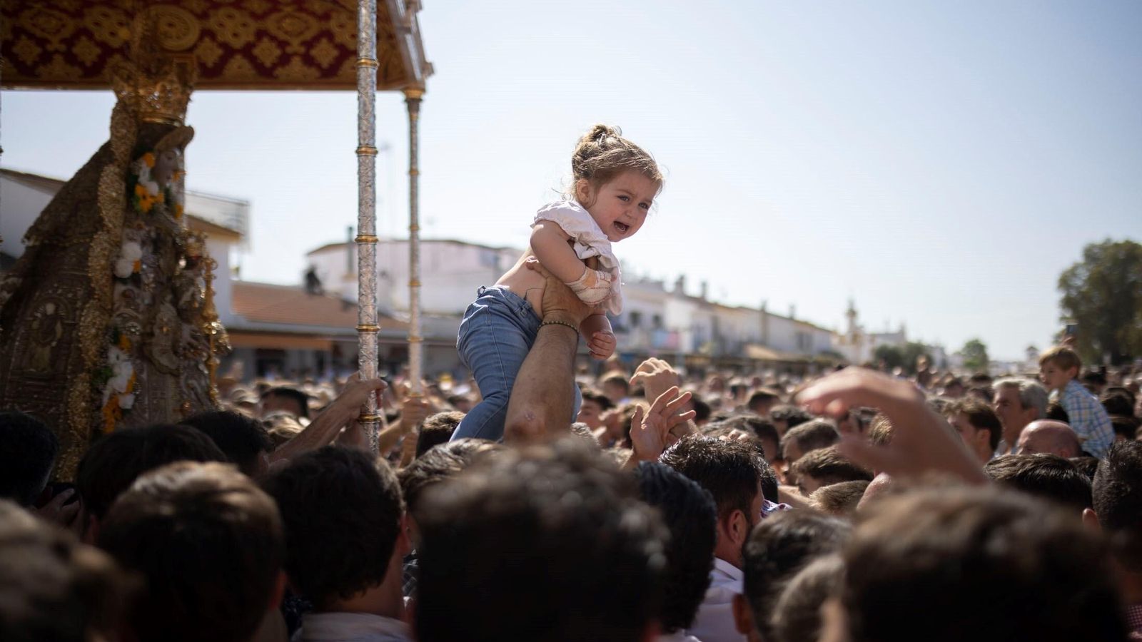 Acercan a una niña a la Blanca Paloma durante la procesión del Lunes de Pentecostés.
