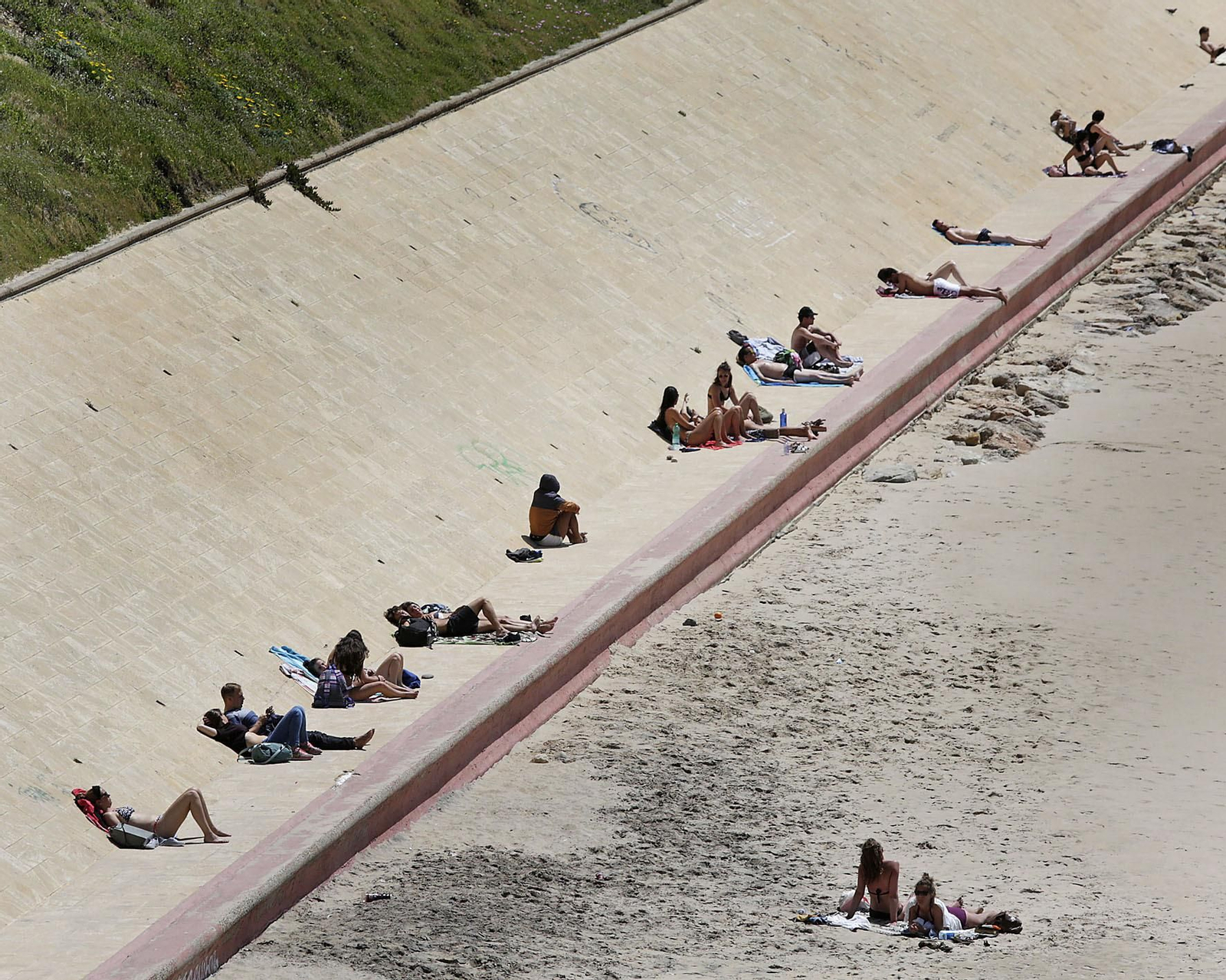 Personas tomando el sol hace unos días en la playa de Santa María del Mar.