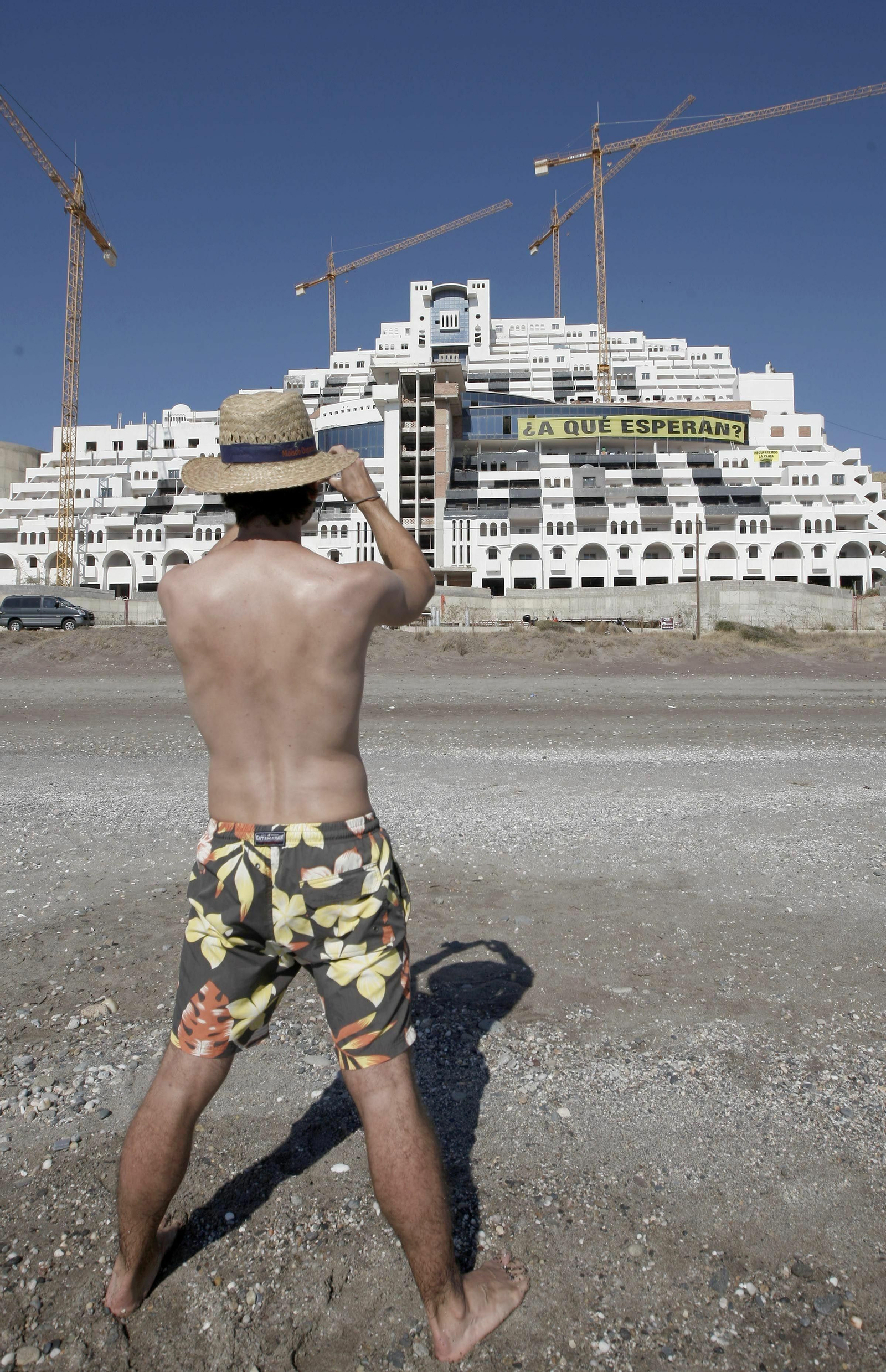 Un hombre hace una foto a la edificación del hotel del Algarrobico.