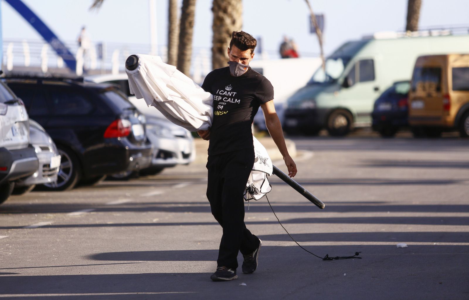 Un trabajador de la hostelería recoge una sombrilla.