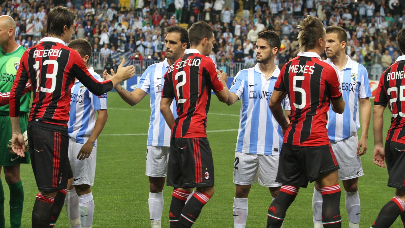 Los jugadores del Málaga se saludan con los del AC Milan en La Rosaleda en un partido de Champions League.
