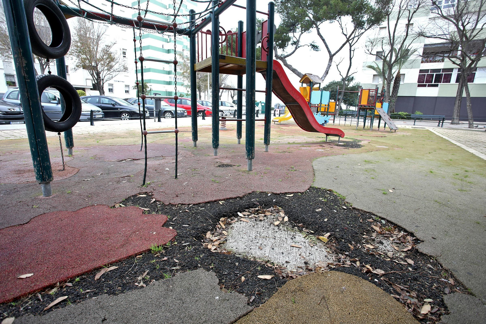 Uno de los boquetes que presenta el suelo de caucho del parque infantil.