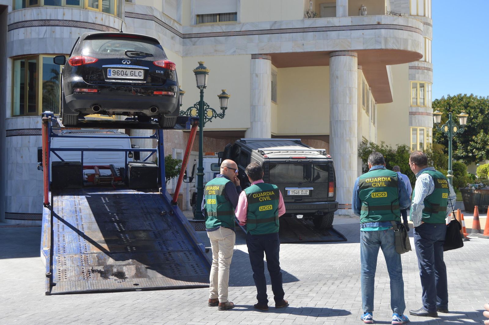 Agentes de la Guardia Civil observan el traslado a una grúa de uno de los vehículos.