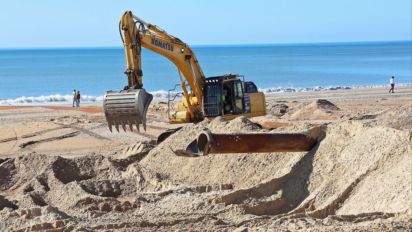 Una excavadora trabajando en la playa de Matalascañas.