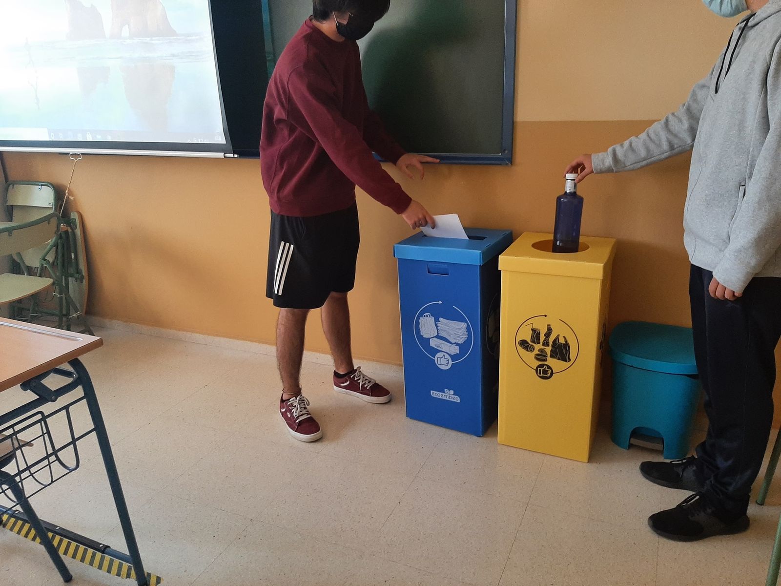Dos alumnos de un centro escolar reciclando residuos.