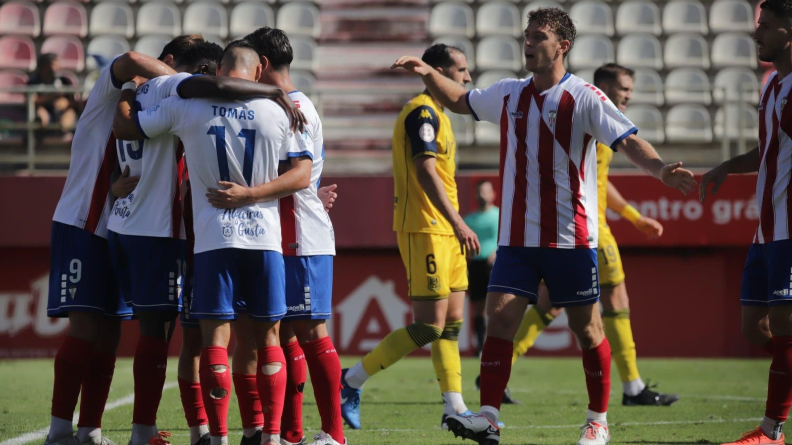 Los algeciristas se funden en un abrazo a Isaac Obeng tras el gol al Alcorcón.