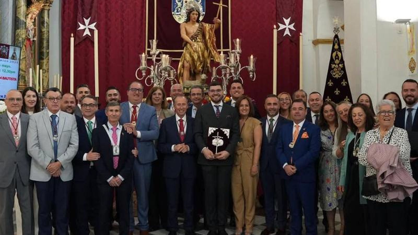 Foto de familia del pregonero, autoridades y miembros de las hermandades ante la imagen del Patrón, tras la celebración del Pregón en la Iglesia de San Telmo.