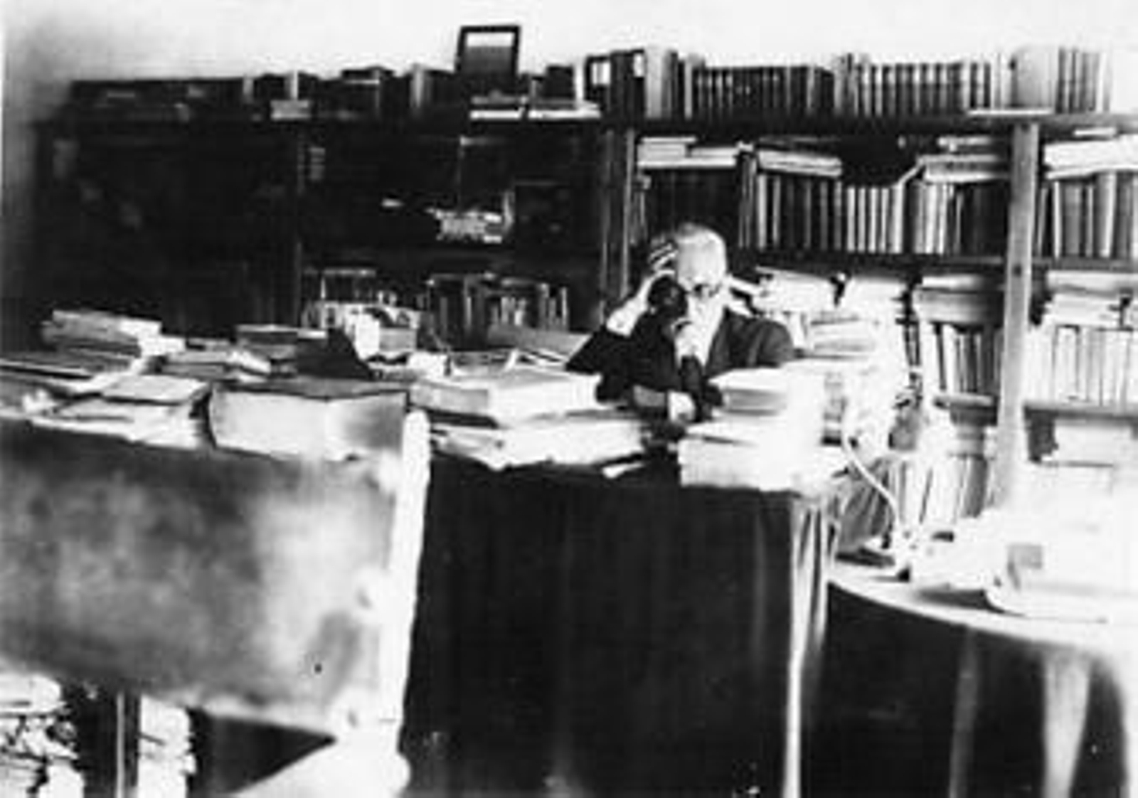 Miguel de Unamuno, rodeado de libros en su despacho.