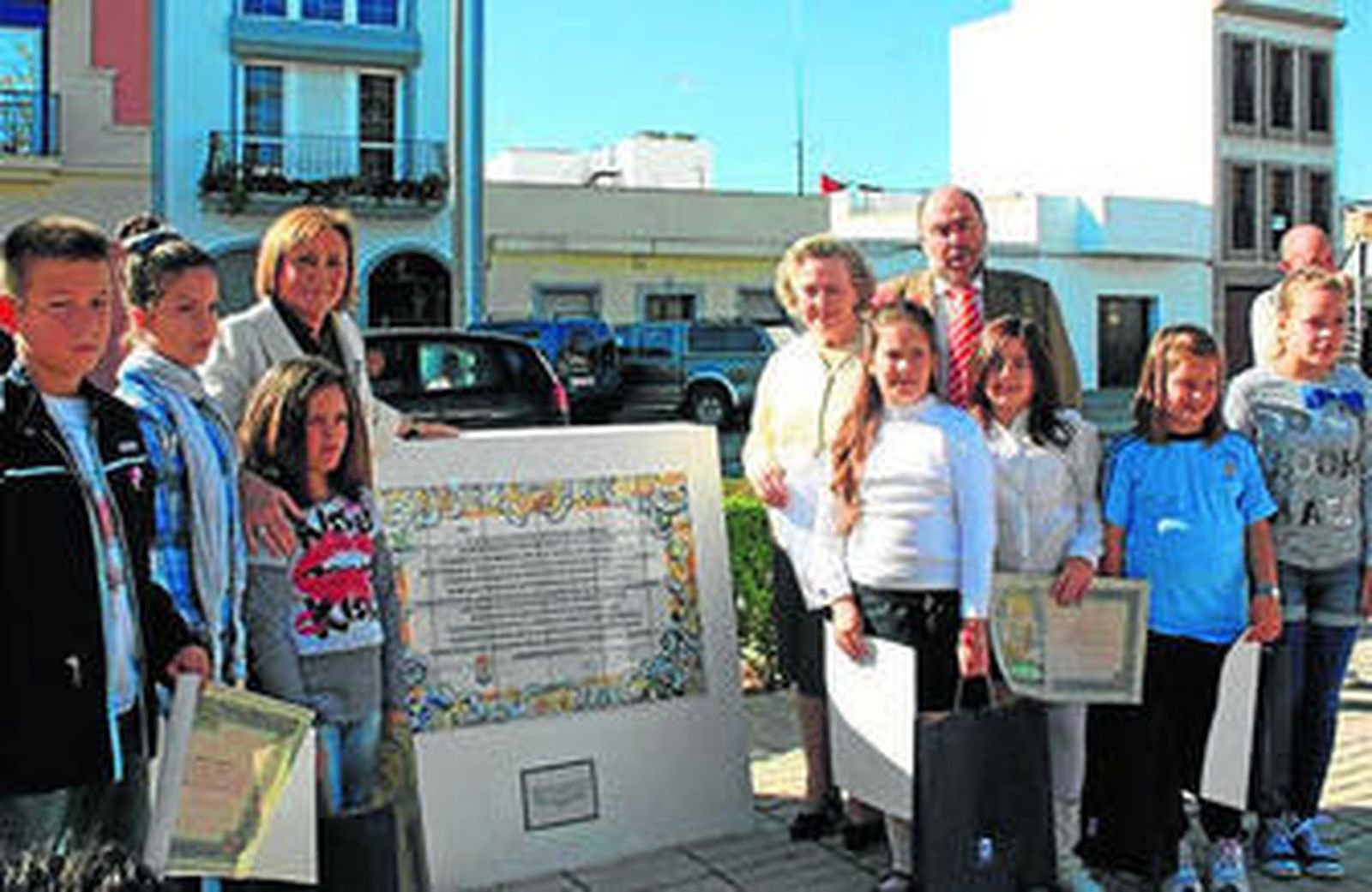 Los niños, que ganaron el concurso de redacción, ante el azulejo.