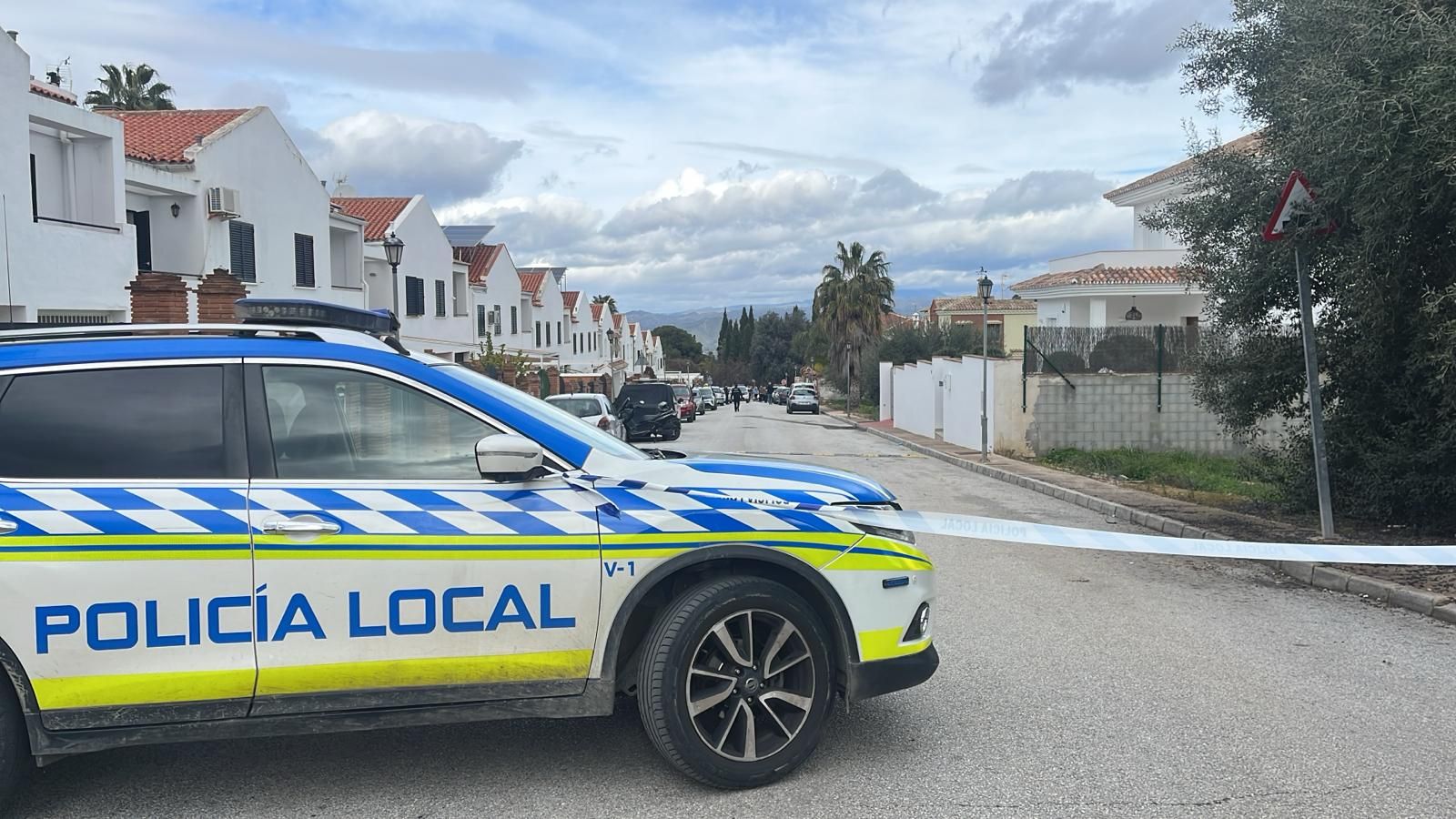 Un coche de la Policía Local de Alhaurín el Grande, en la entrada a la urbanización en la que han sucedido los hechos.