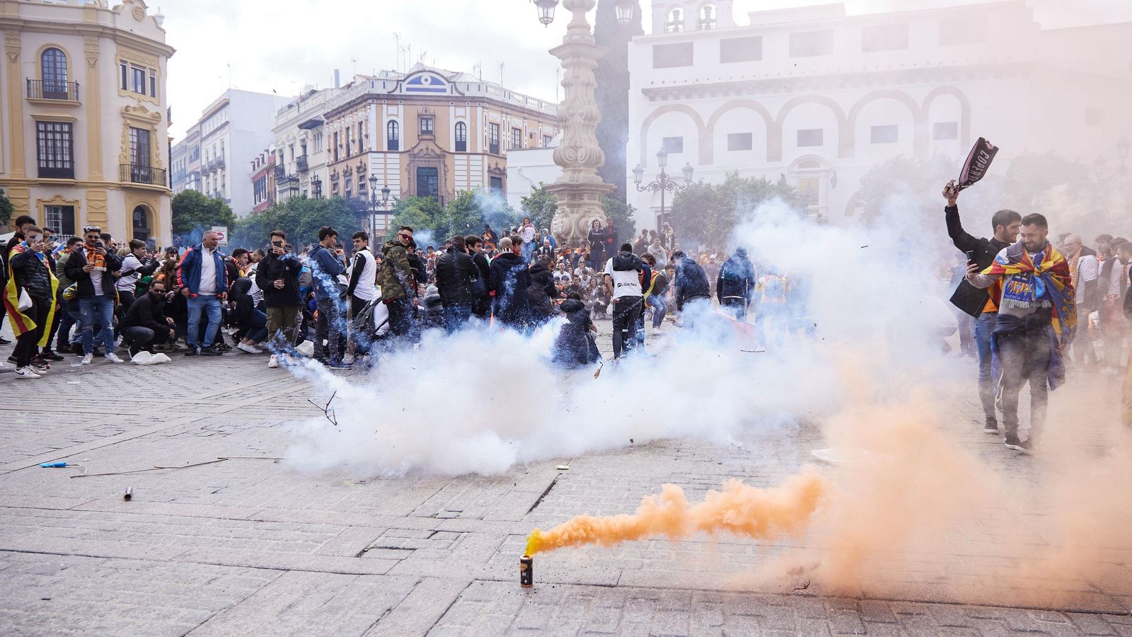 Los aficionados del Valencia con botes de humo festejando en la Plaza Virgen de los Reyes.