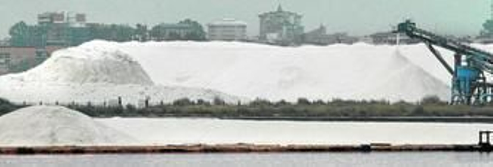Montaña de sal ubicada en pleno paraje natural en la que deposita su producción Salinas del Odiel, con la ciudad de Huelva al fondo.