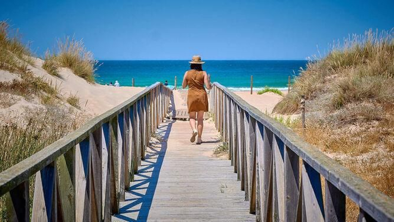 Una mujer accediendo a la playa. Una mujer accediendo a la playa.