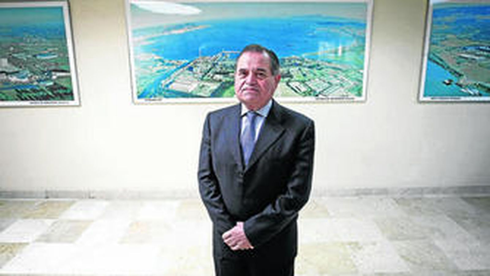 José Luis Masi posa delante de una fotografía aérea de la factoría de Palmones en el interior del edificio de oficinas de la fábrica.