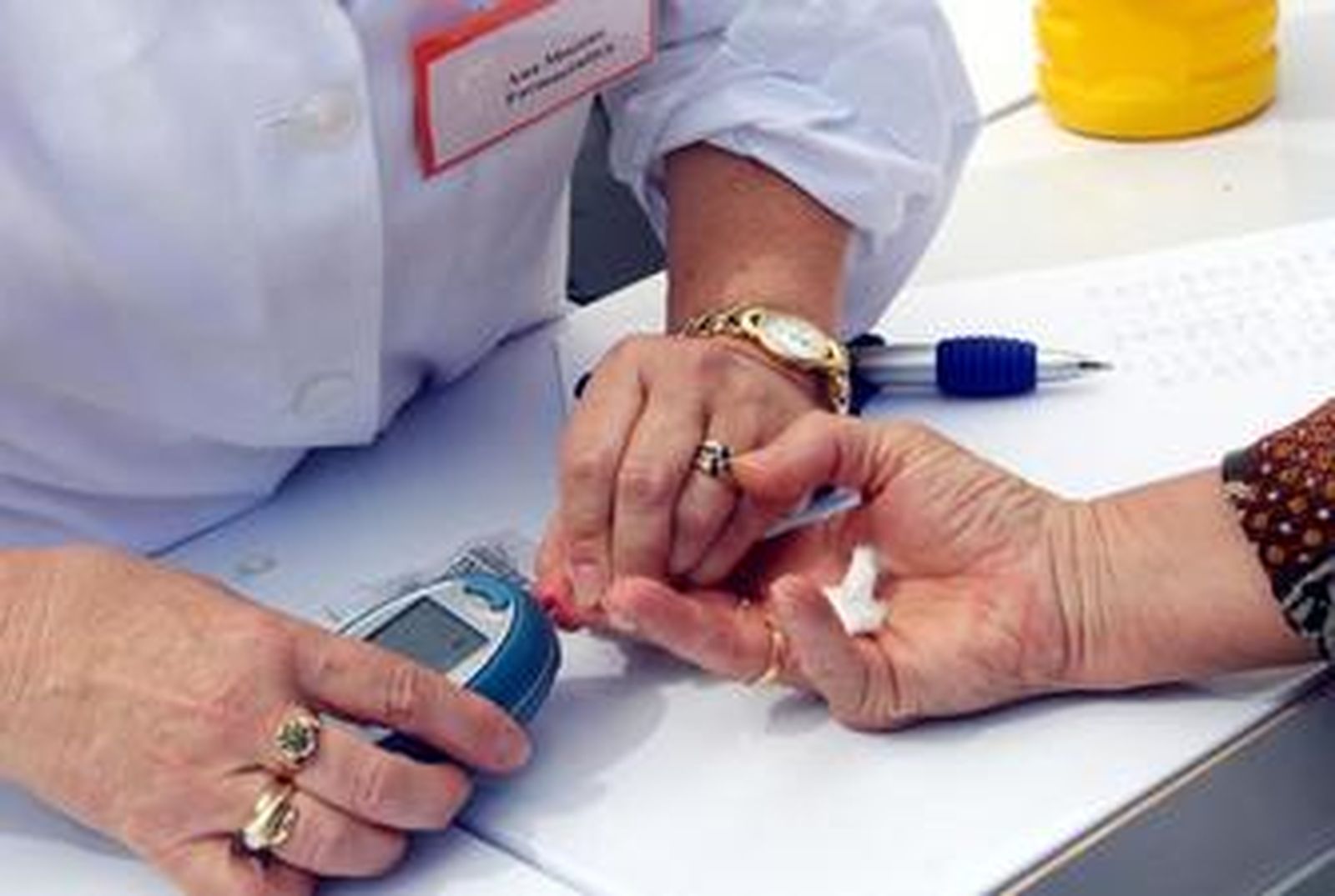 Una farmacéutica le realiza la prueba de la glucosa a una paciente.