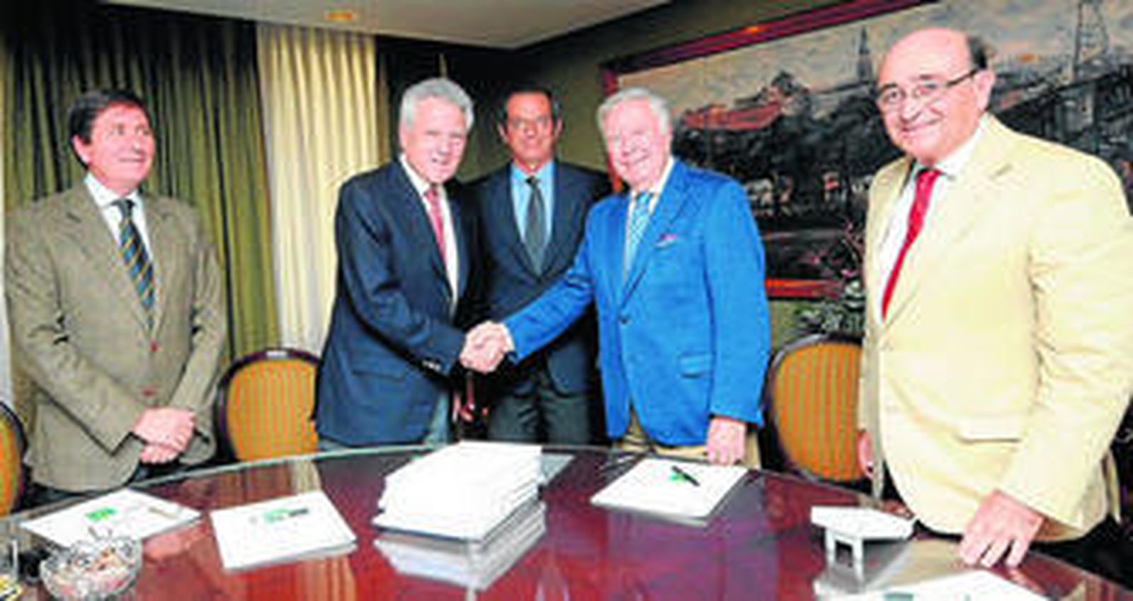 Los presidentes de las dos cajas se dan la mano tras la firma de la fusión, ante notario, ayer.