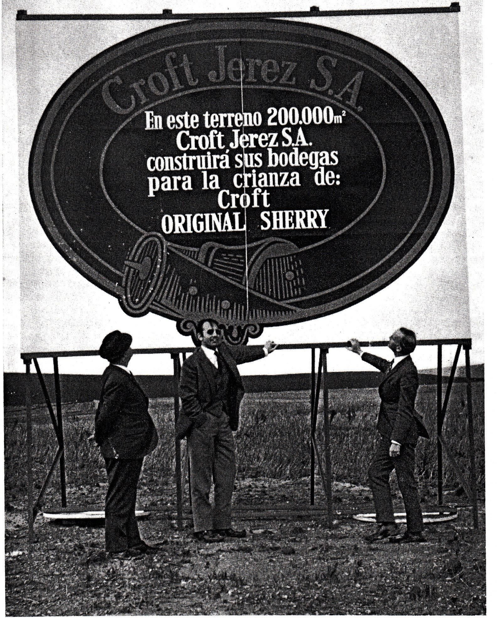 Manuel Morales Rodríguez, Manuel Zarraluqui y Mr. Alan Martin ante el panel que anunciaba la nueva bodega, 1972.