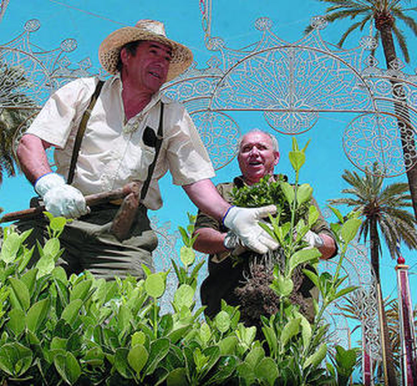 Dos operarios municipales colocan plantas, ayer, en una de las rotondas del Real del González Hontoria.