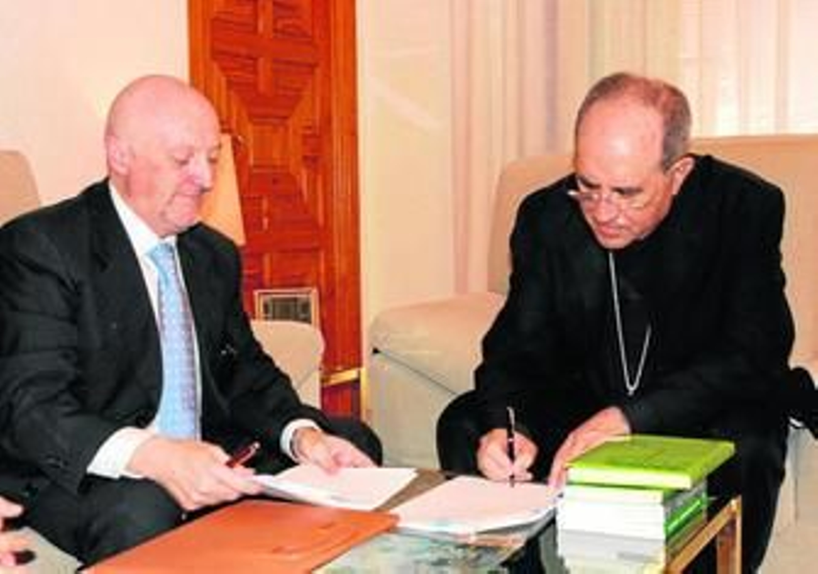 Monseñor Asenjo firma el acuerdo de cesión en presencia del notario Manuel Seda.