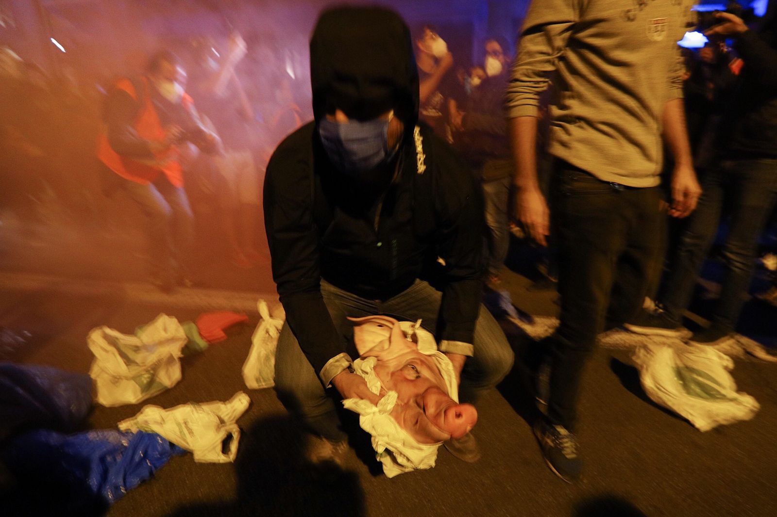 Miembros de los CDR arrojando cabezas de cerdo a los Mossos d’Esquadra ante la Delegación del Gobierno en Barcelona este lunes por la noche.