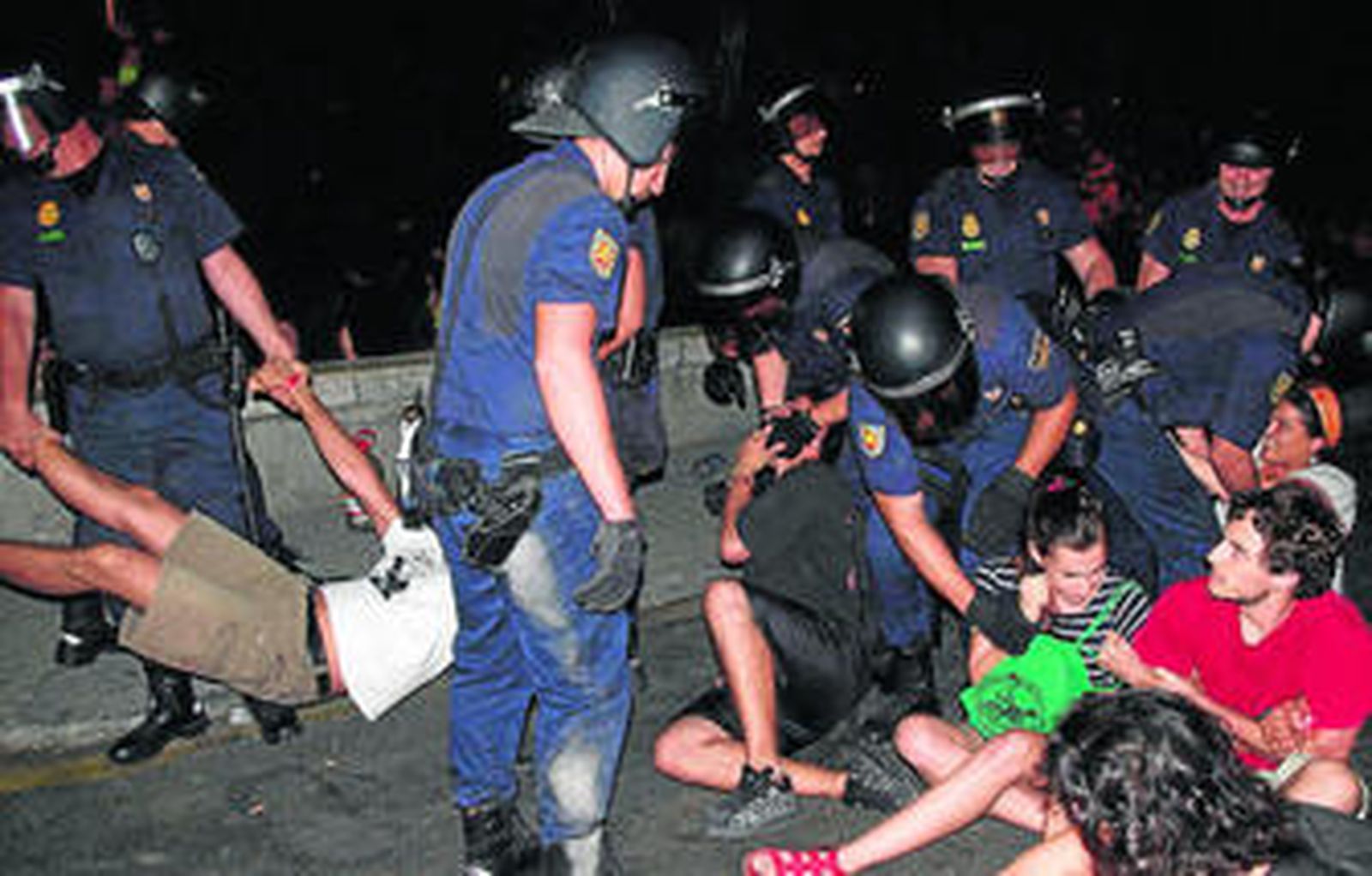 Agentes antidisturbios desalojan a los indignados del CIE de Málaga, el domingo por la noche.