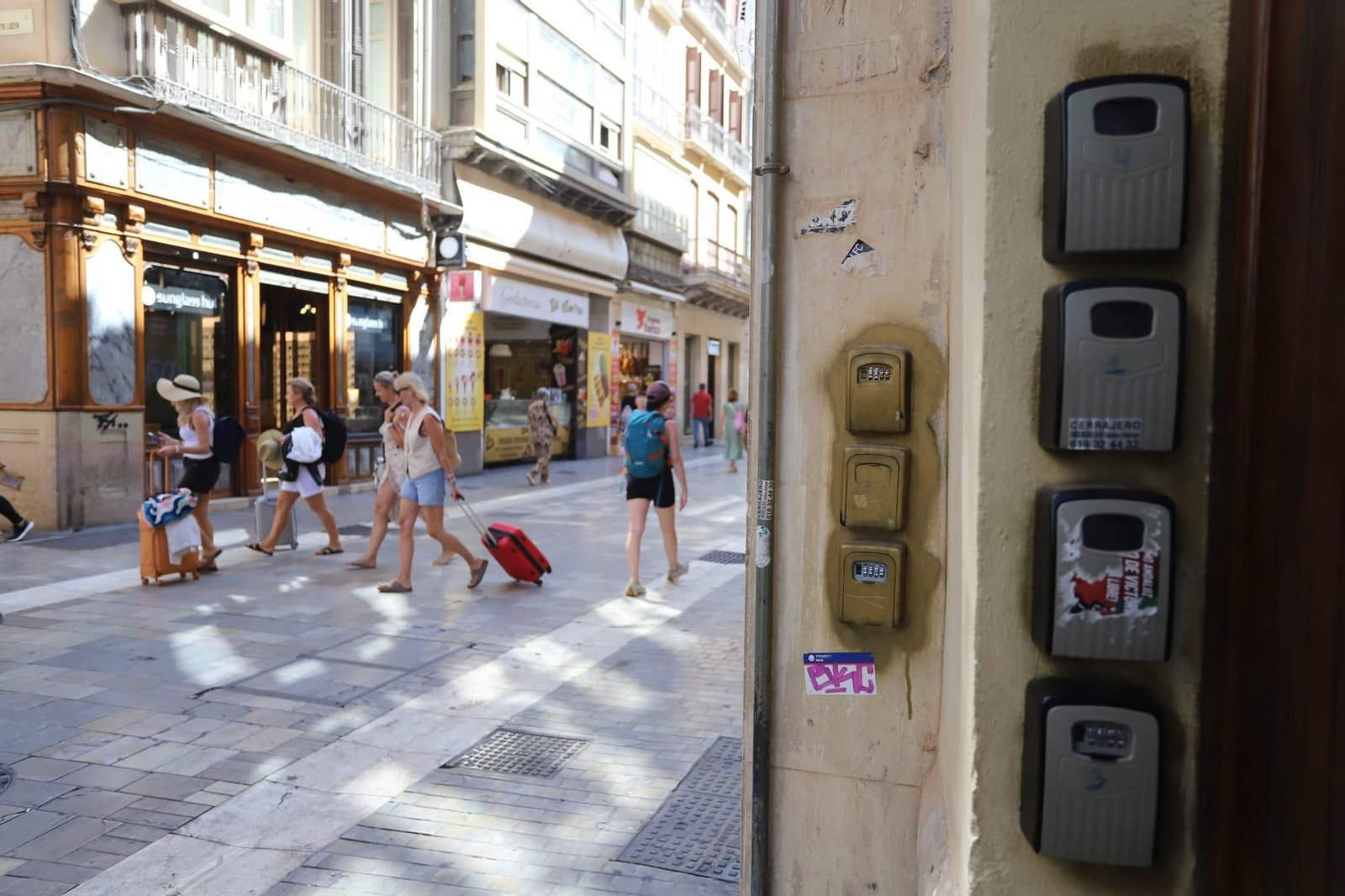 Turistas frente a un portal del Centro con cajetines para llaves.