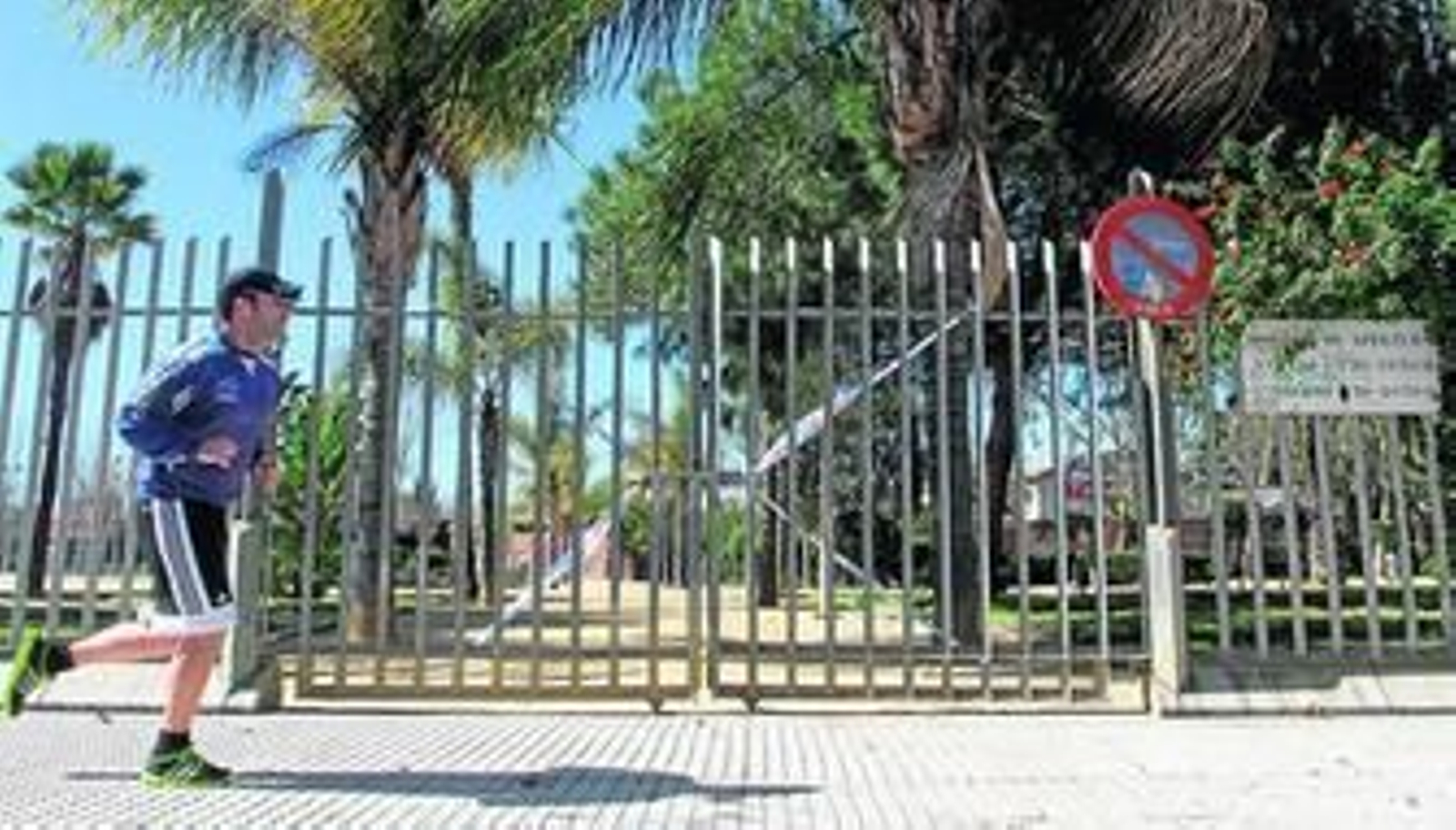 Un corredor pasa junto a uno de los accesos del parque, cerrado a cal y canto desde la semana pasada.