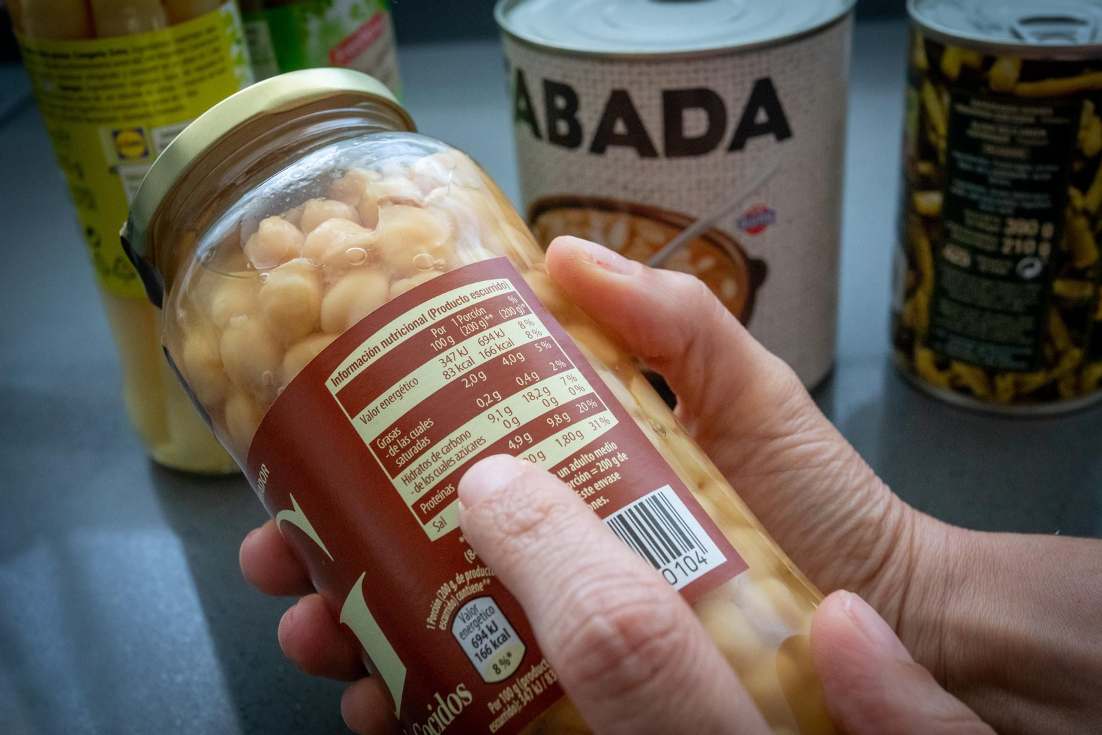 Una persona consulta la información nutricional de un bote de legumbres.