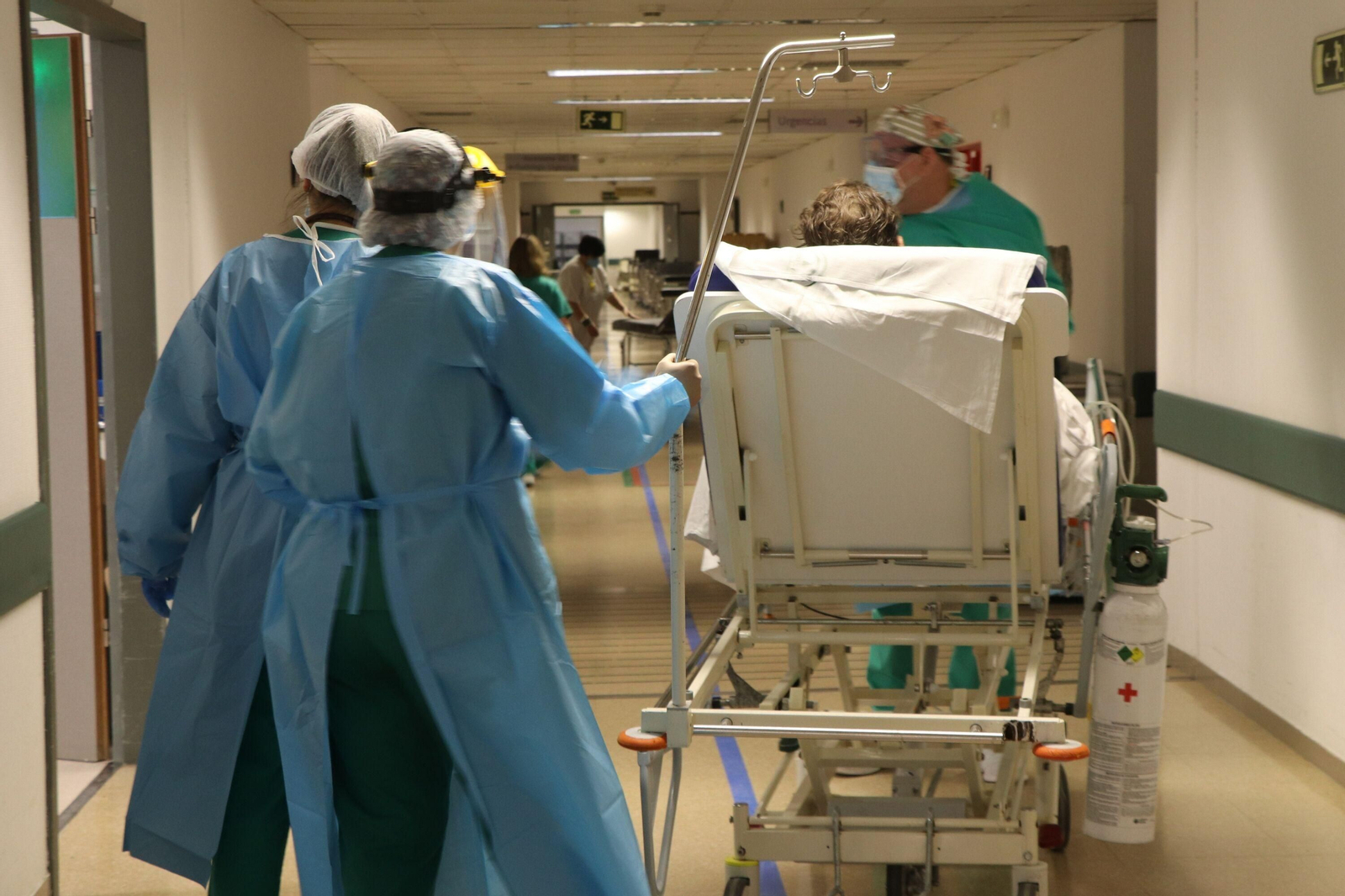 Profesionales médicos atienden  a un paciente con coronavirus  en el Reina Sofía.