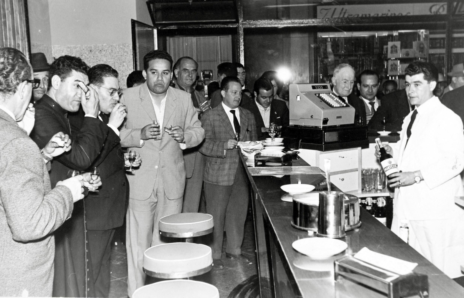Emilio Sancho Mejías, al frente de la barra, con un grupo de invitados, durante la inauguración de la Cafetería Bar Piccola, en 1962.
