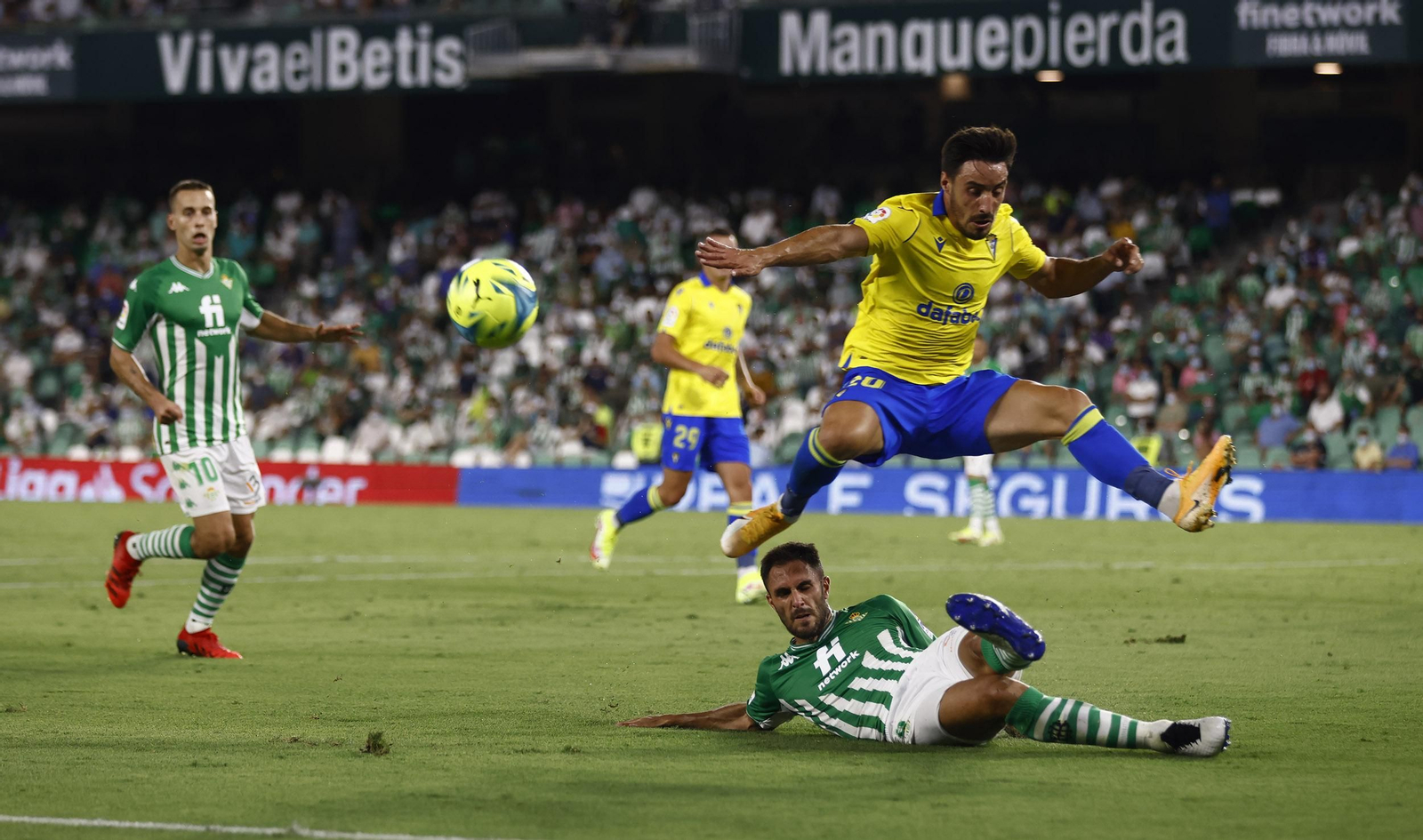 Iza Carcelén salta por encima de un jugador del Betis.