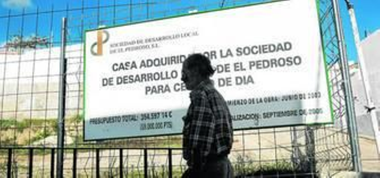 Un hombre pasa por delante de una de las obras subvencionadas en el pueblo, con fecha de finalización en 2005.