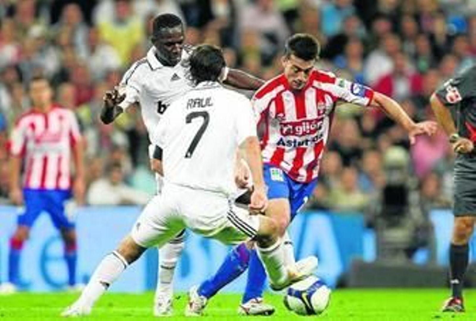 Kike Mateo, con el Sporting, trata de zafarse de Raúl y Diarrá, del Madrid.