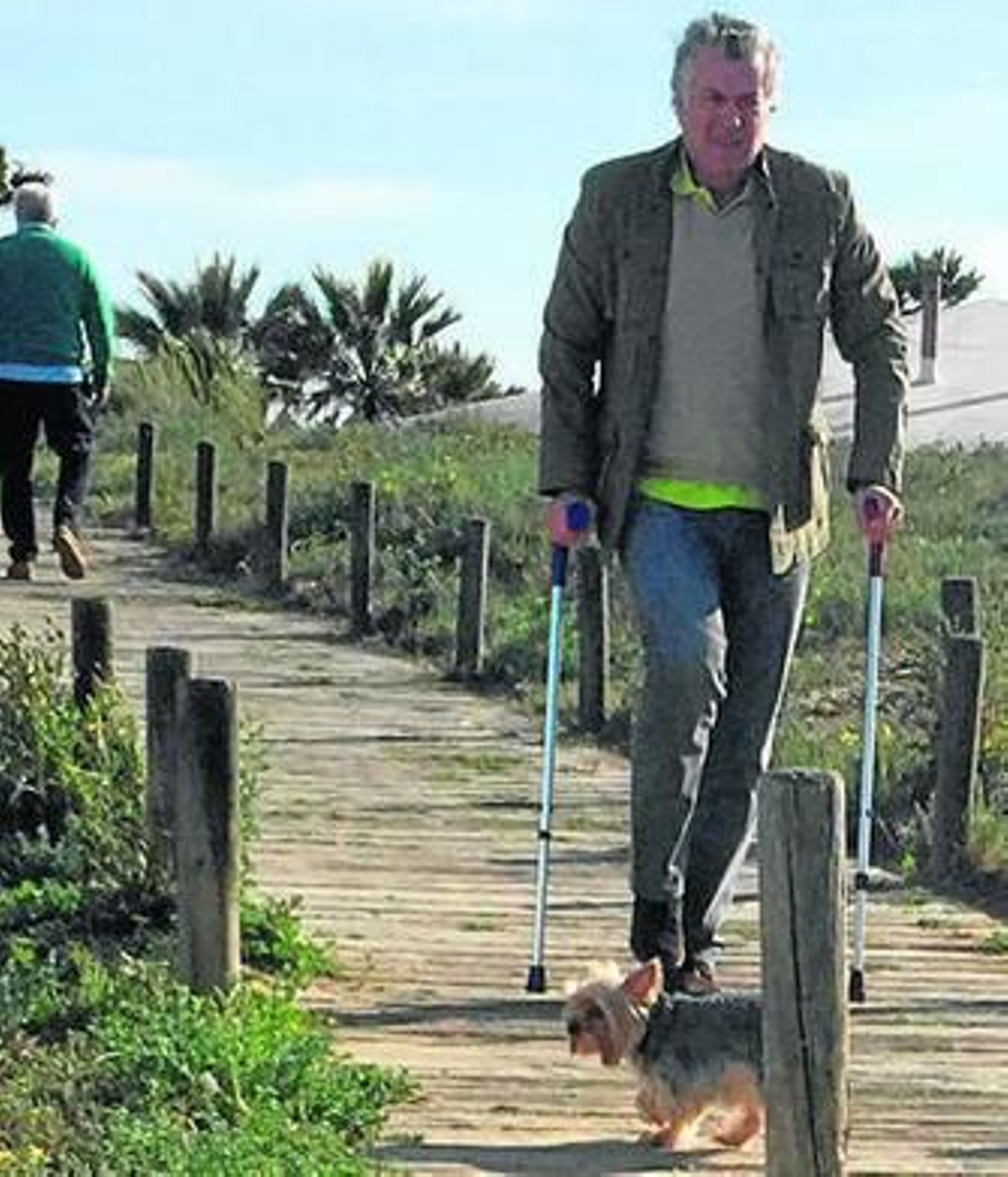 Arriba. Bárcenas y su perro, al abandonar el restaurante. Sobre estas líneas, al sol en la terraza de la playa.