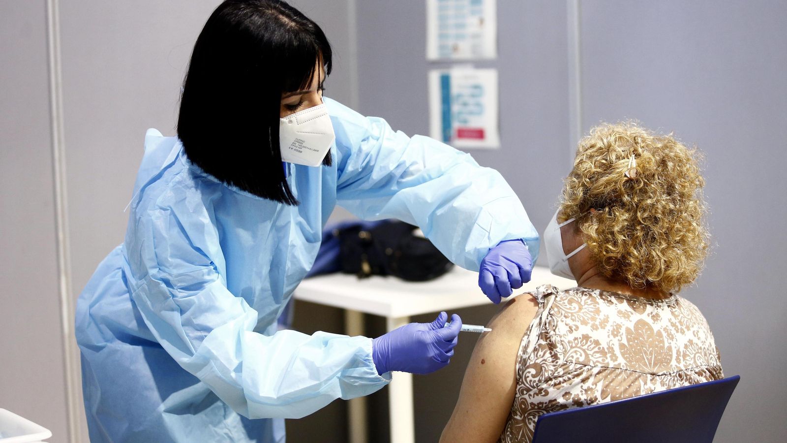 Una enfermera inoculando a una mujer.