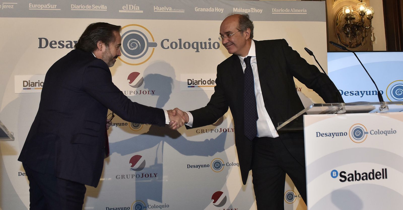 Alberto Grimaldi, redactor jefe de Economía de Grupo Joly y moderador del desayuno-coloquio, saluda a Cirus Andreu, presidente ejecutivo de Sabadell Asset Management
