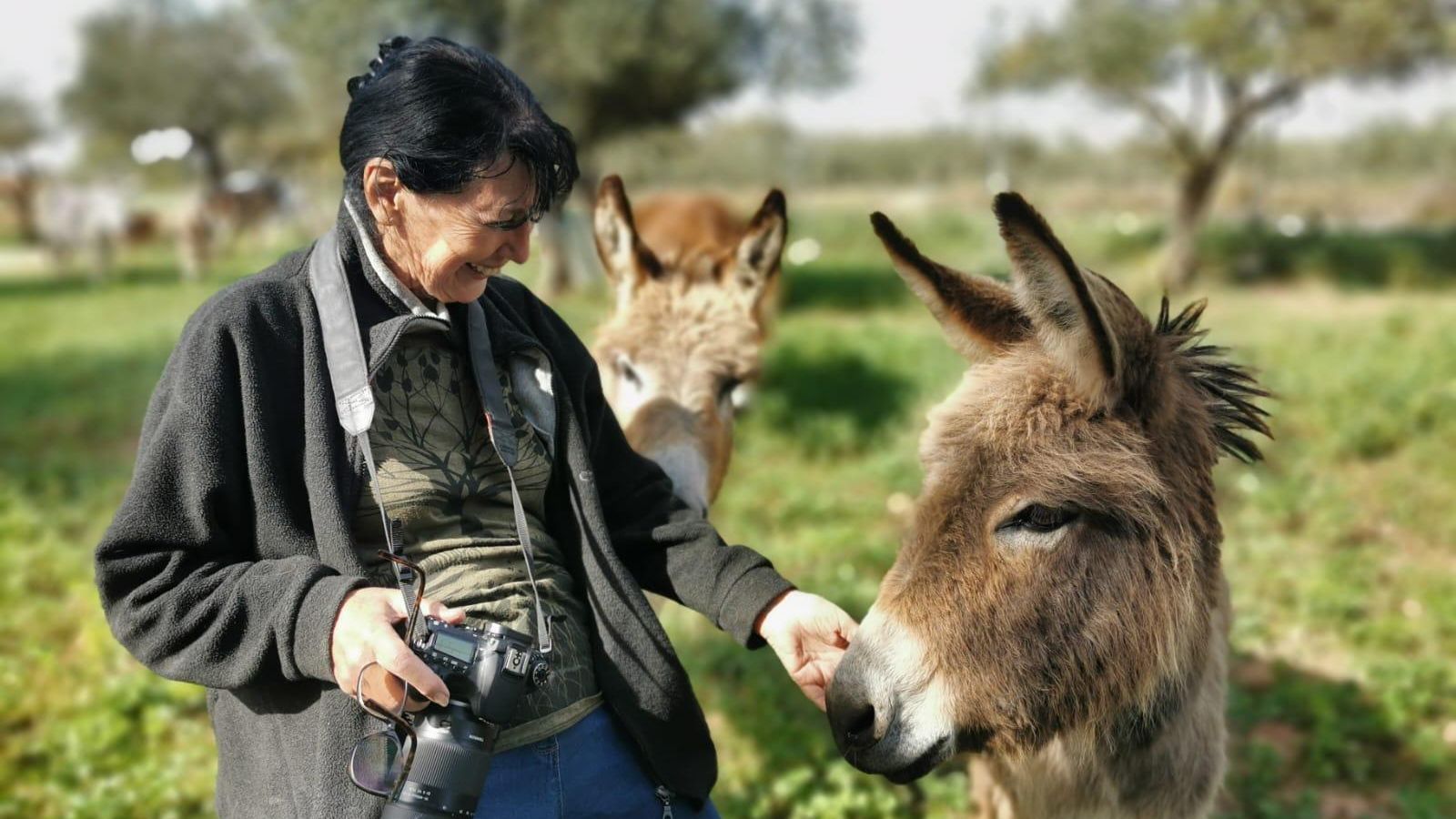 Turista canadiense disfrutando de la compañía de los burros.