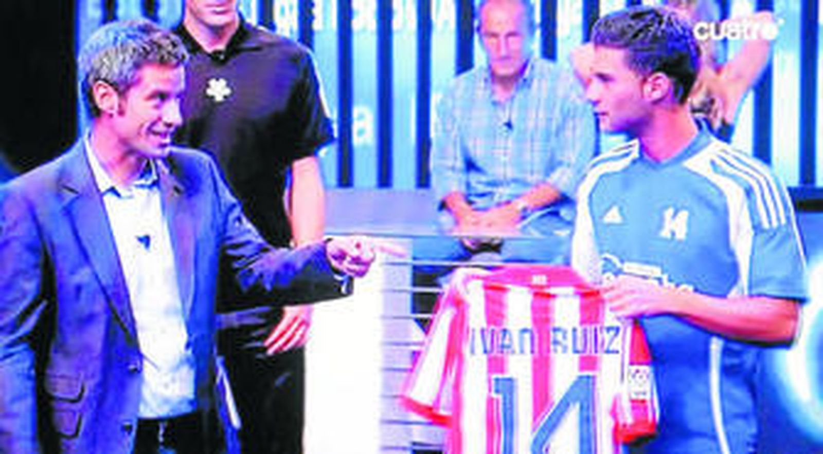 Iván Ruiz sostiene su camiseta del Atlético de Madrid junto al presentador de Cuatro Nico Abad.