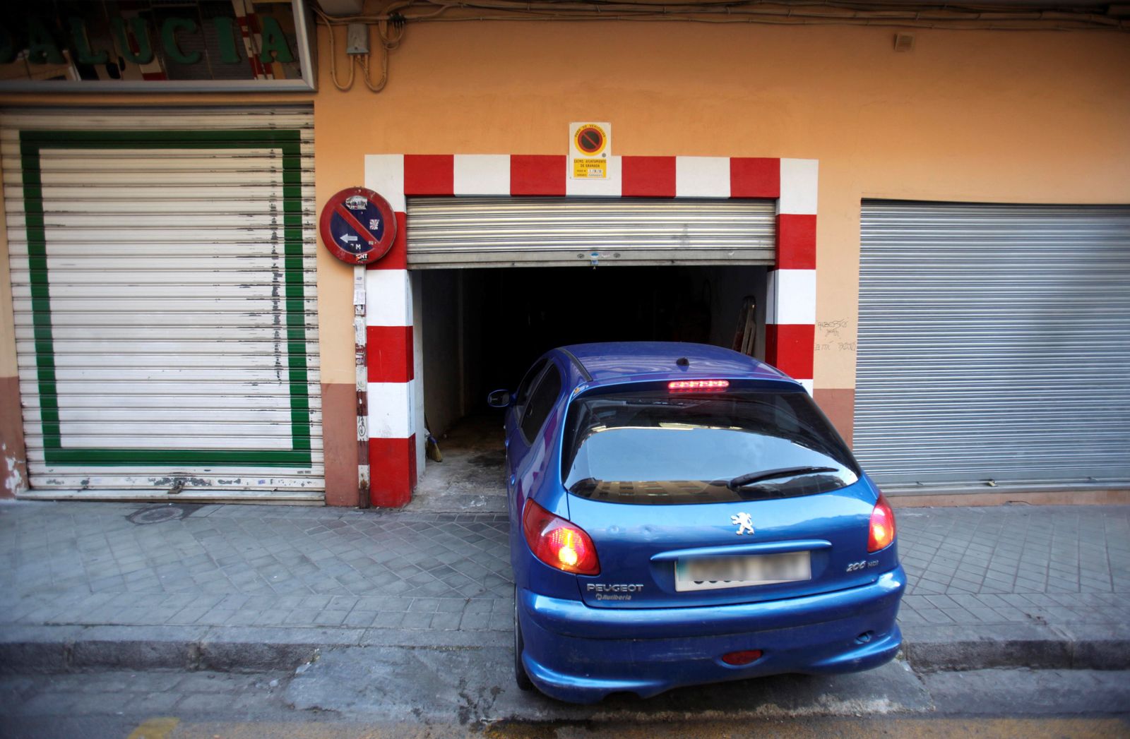 Un coche accede al garaje con señal de vado