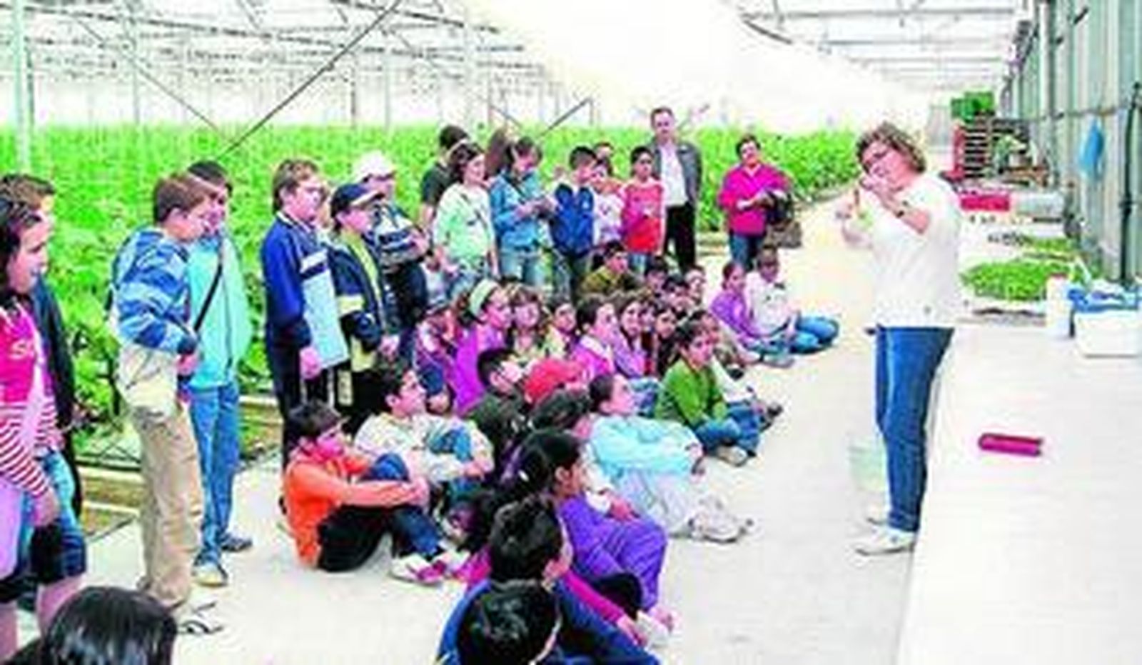 Lola Gómez durante la visita de unos niños en su invernadero.
