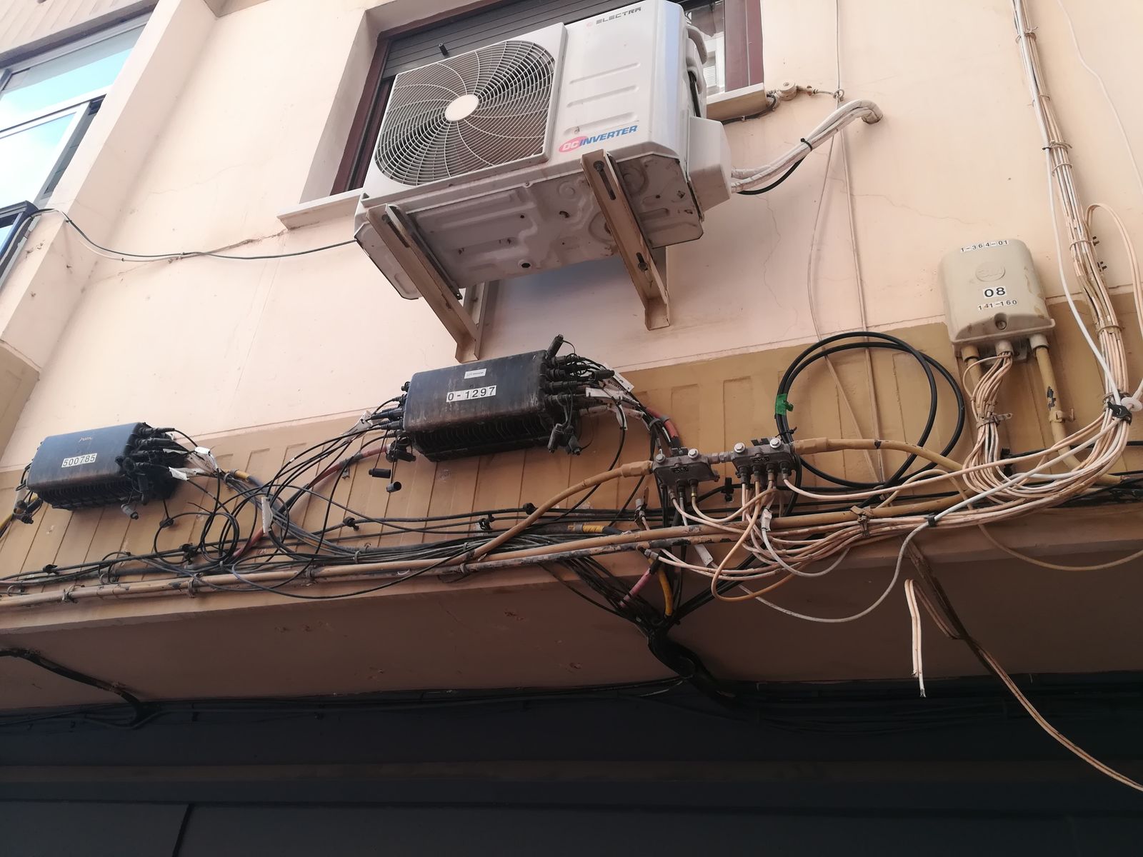 Estampa de una fachada "decorada" con un sinfín de cables y enganches
