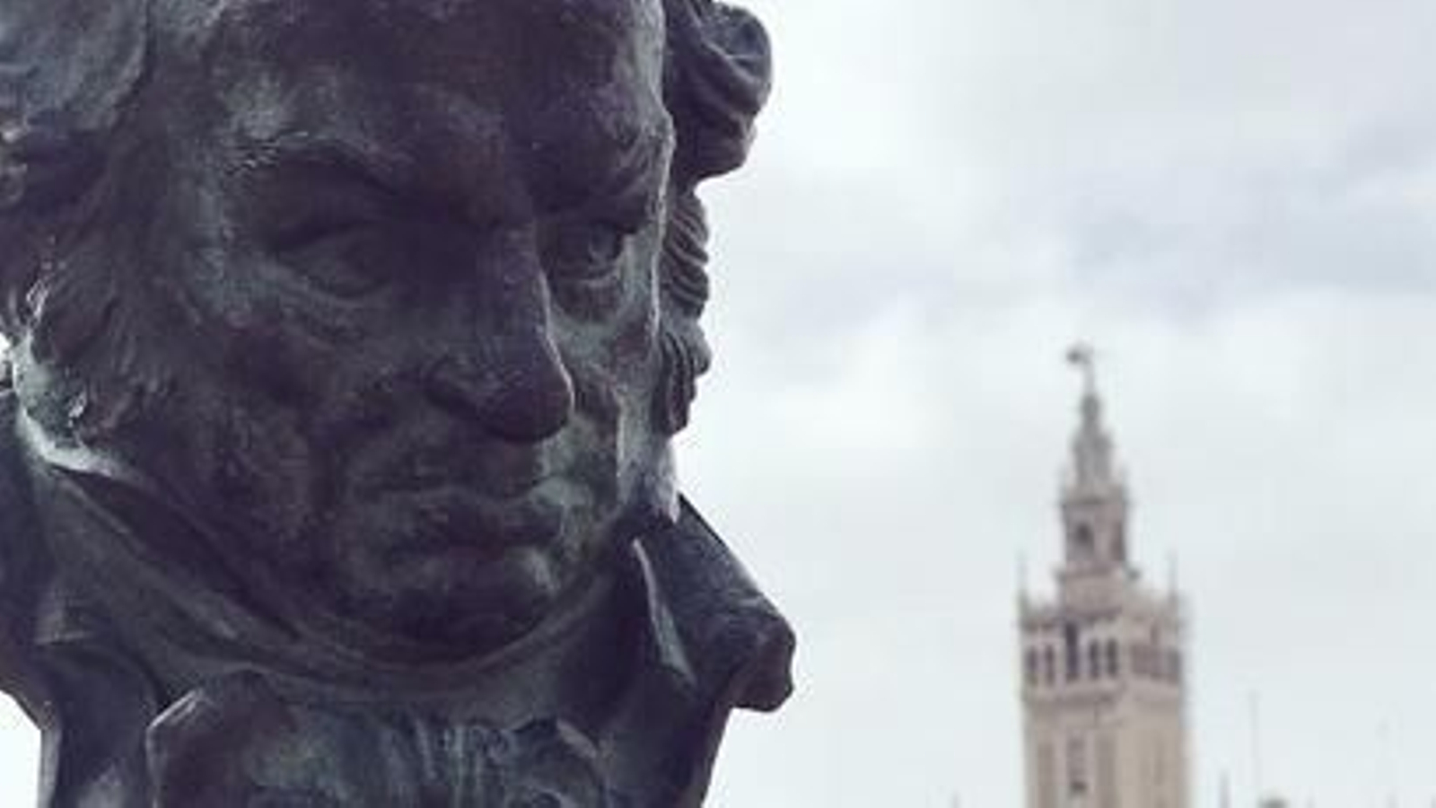 Una estatuilla de los Goya con la Giralda al fondo.
