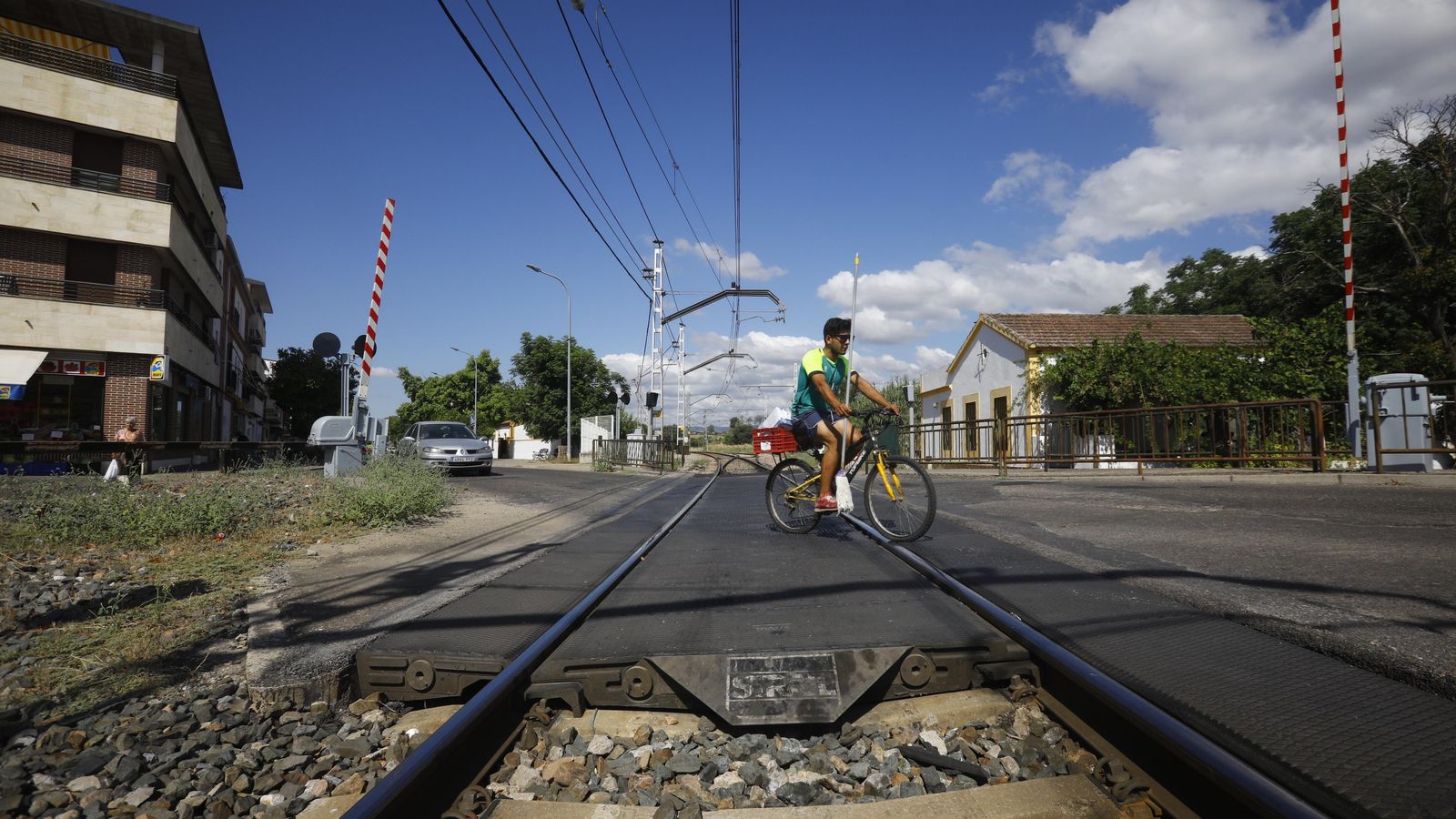 Un hombre en bicicleta atraviesa las vías del ten.